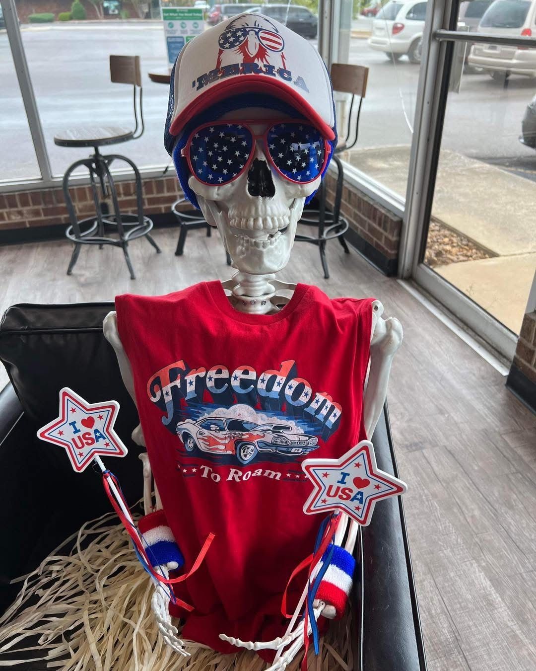 Skeleton decorated in patriotic attire: hat, sunglasses, shirt, and wands, possibly for Independence Day. | Total Automotive