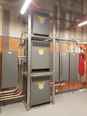 A room with a lot of electrical equipment stacked on top of each other.