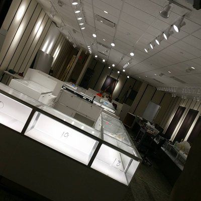 A jewelry store with lots of display cases and lights on the ceiling.