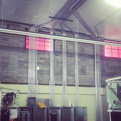 A room with a lot of pipes hanging from the ceiling