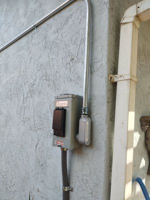 A electrical box is attached to the side of a building.