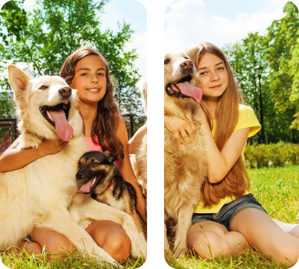 Two girls are sitting in the grass with their dogs