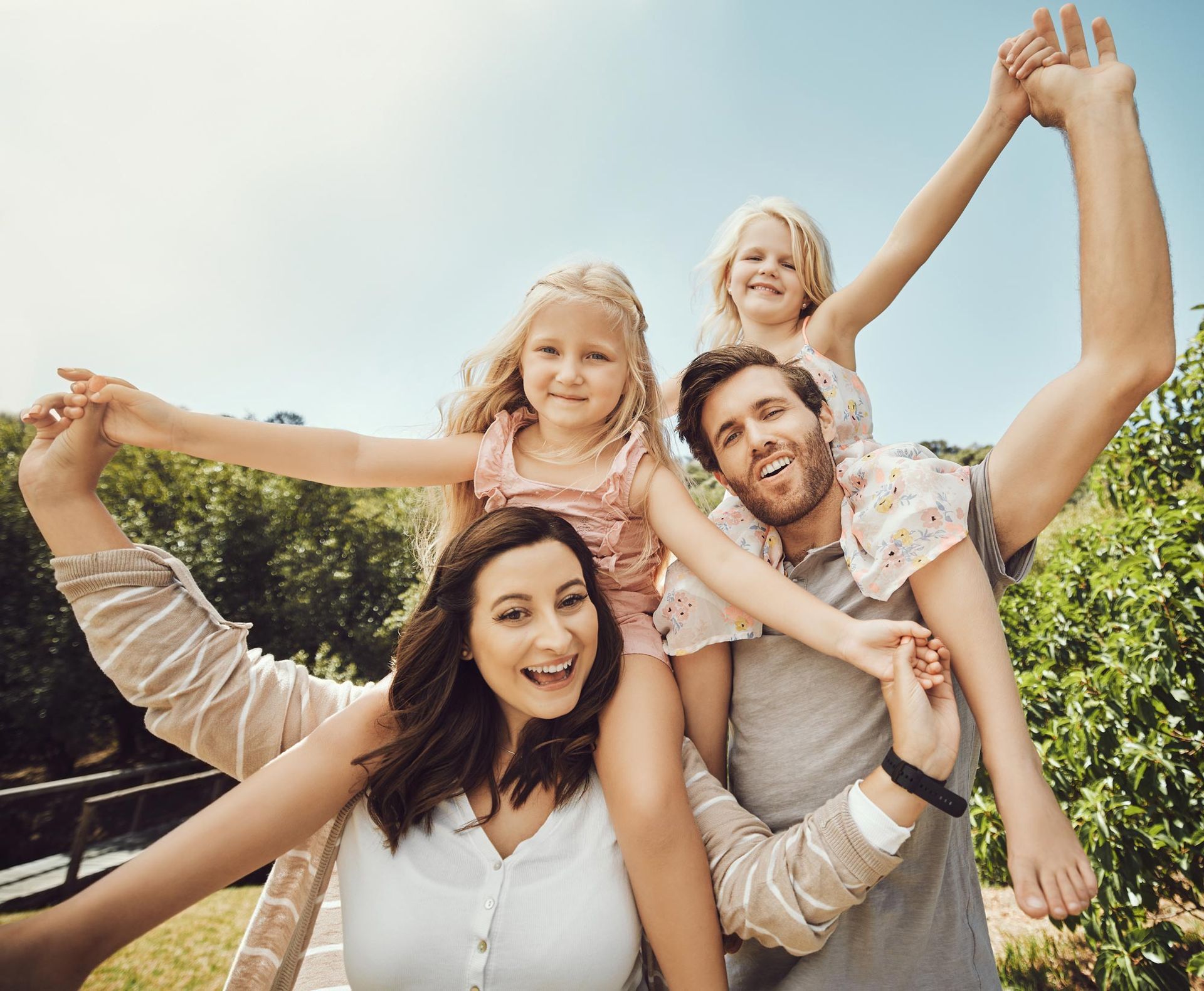 A family is posing for a picture with their arms outstretched.