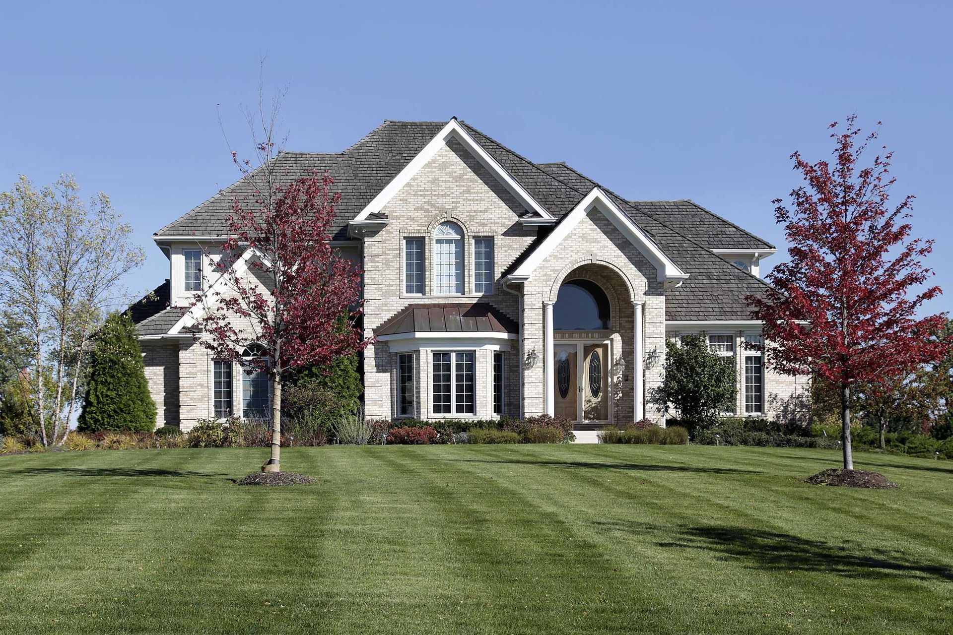 A large house with a lush green lawn in front of it