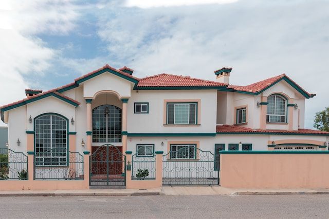 A large white house with a red tile roof and green trim.