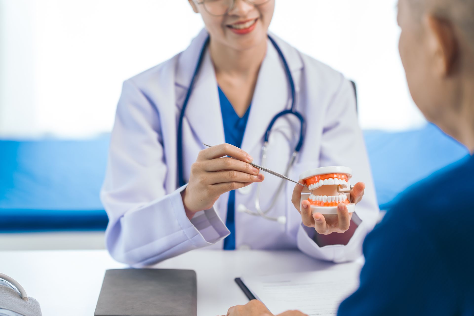 Doctor showing a dental model to a patient during a consultation Doctor showing a dental model to a patient during a consultation