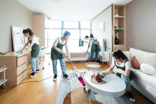 A group of women are cleaning a living room.