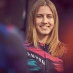 Blonde woman in cycling gear smiling, Canyon logo visible.