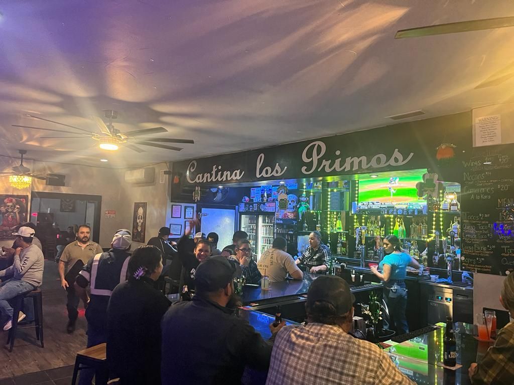 A group of people are sitting at a bar in a restaurant.