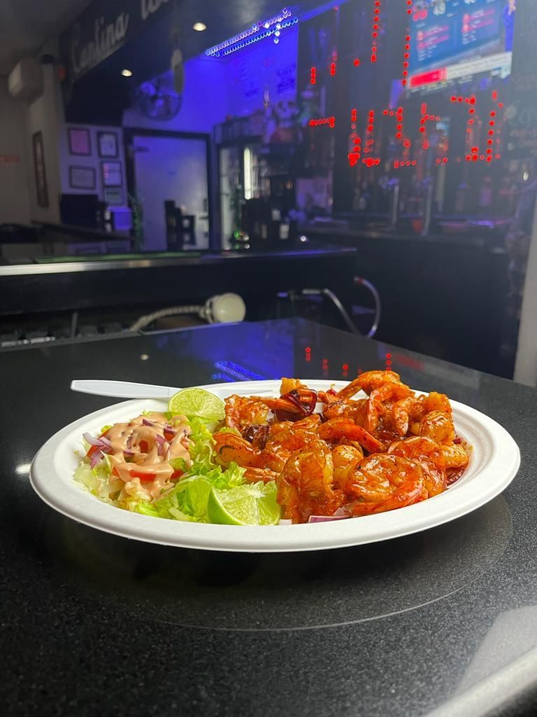 A plate of food with shrimp and lettuce on a table.