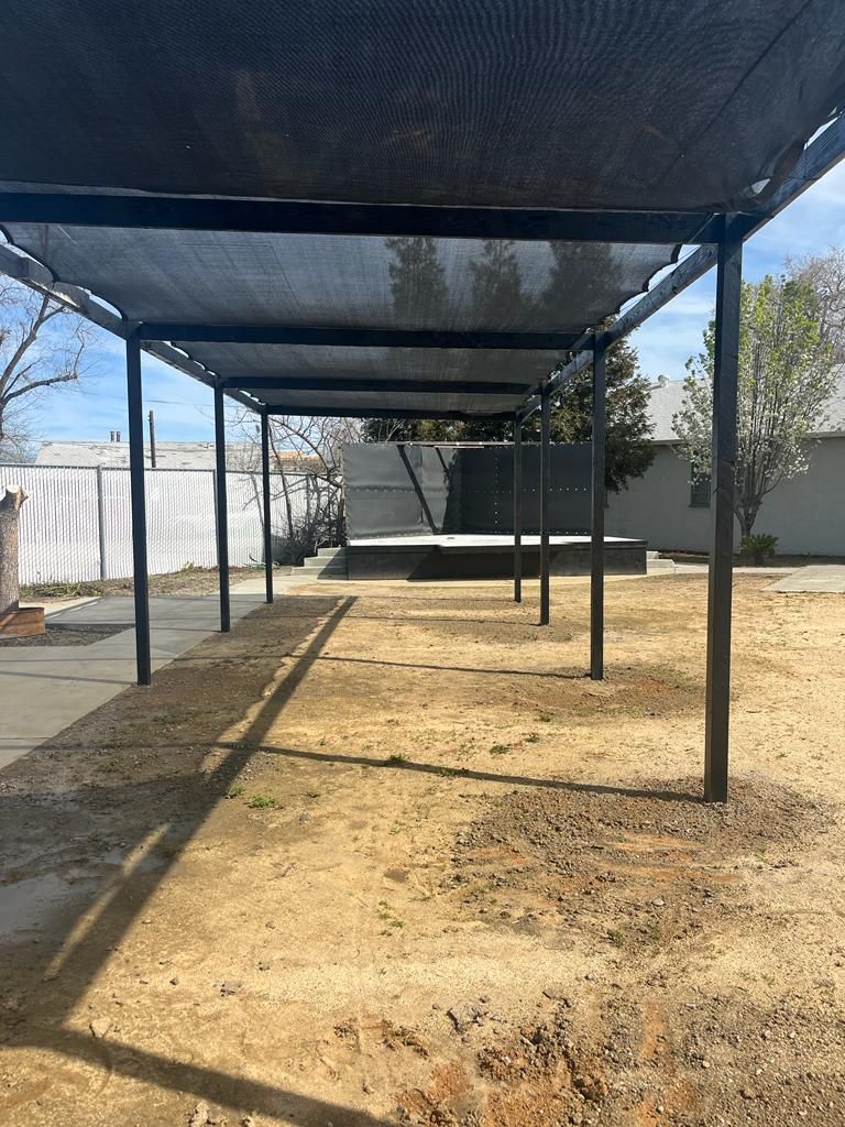 A row of shade structures sitting on top of a dirt field.