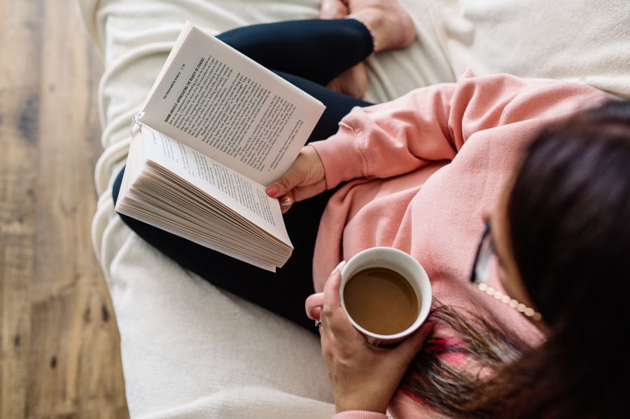 A woman wearing glasses is sitting in a field of tall grass.