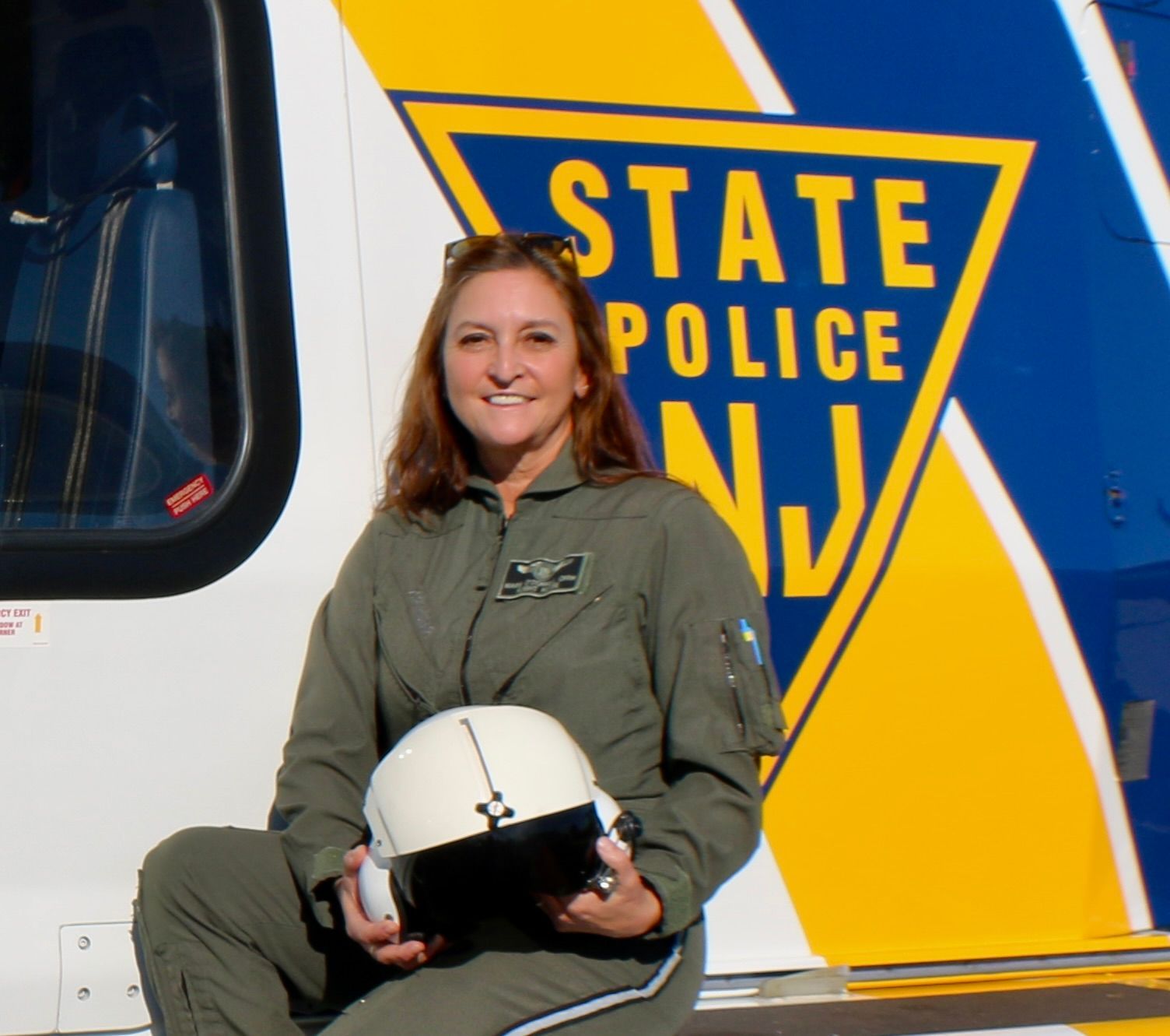A woman sitting in front of a state police helicopter
