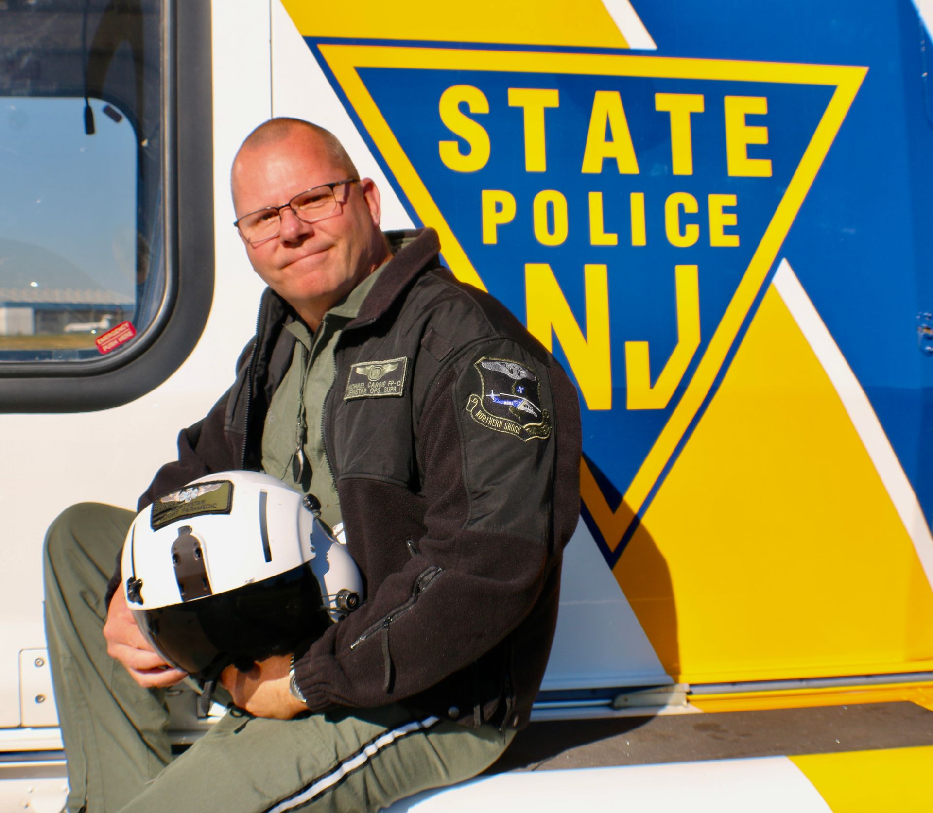 A man sitting on the side of a state police truck
