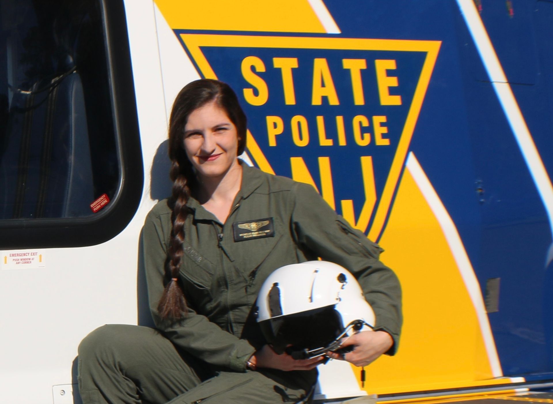 A woman sitting in front of a state police helicopter