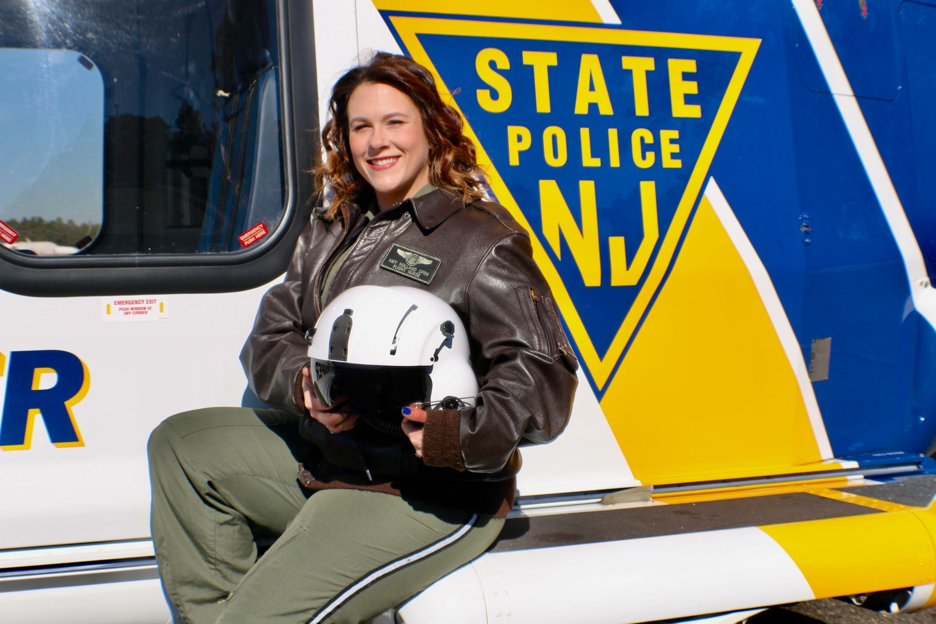 A man in a military uniform is standing in front of a helicopter.