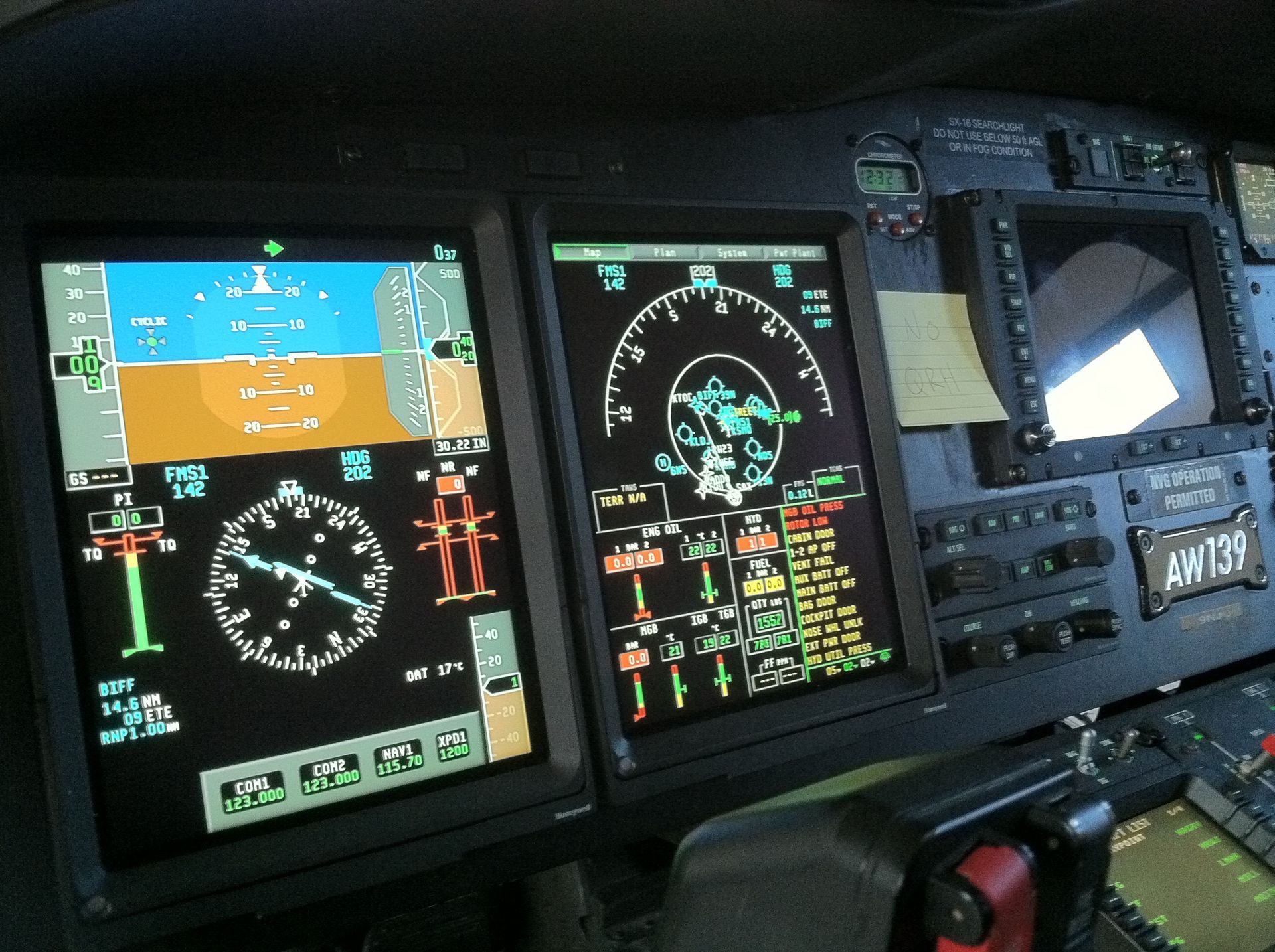 An airplane cockpit with a clock and a few other monitors