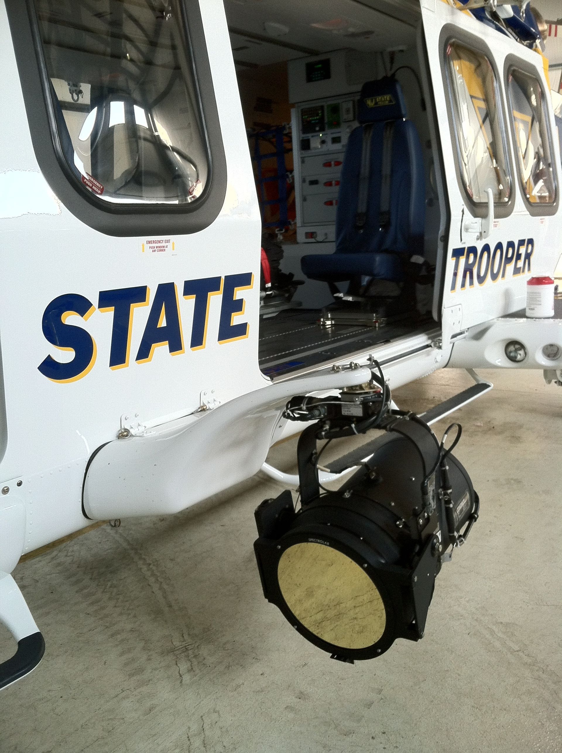 A state trooper helicopter is parked in a garage