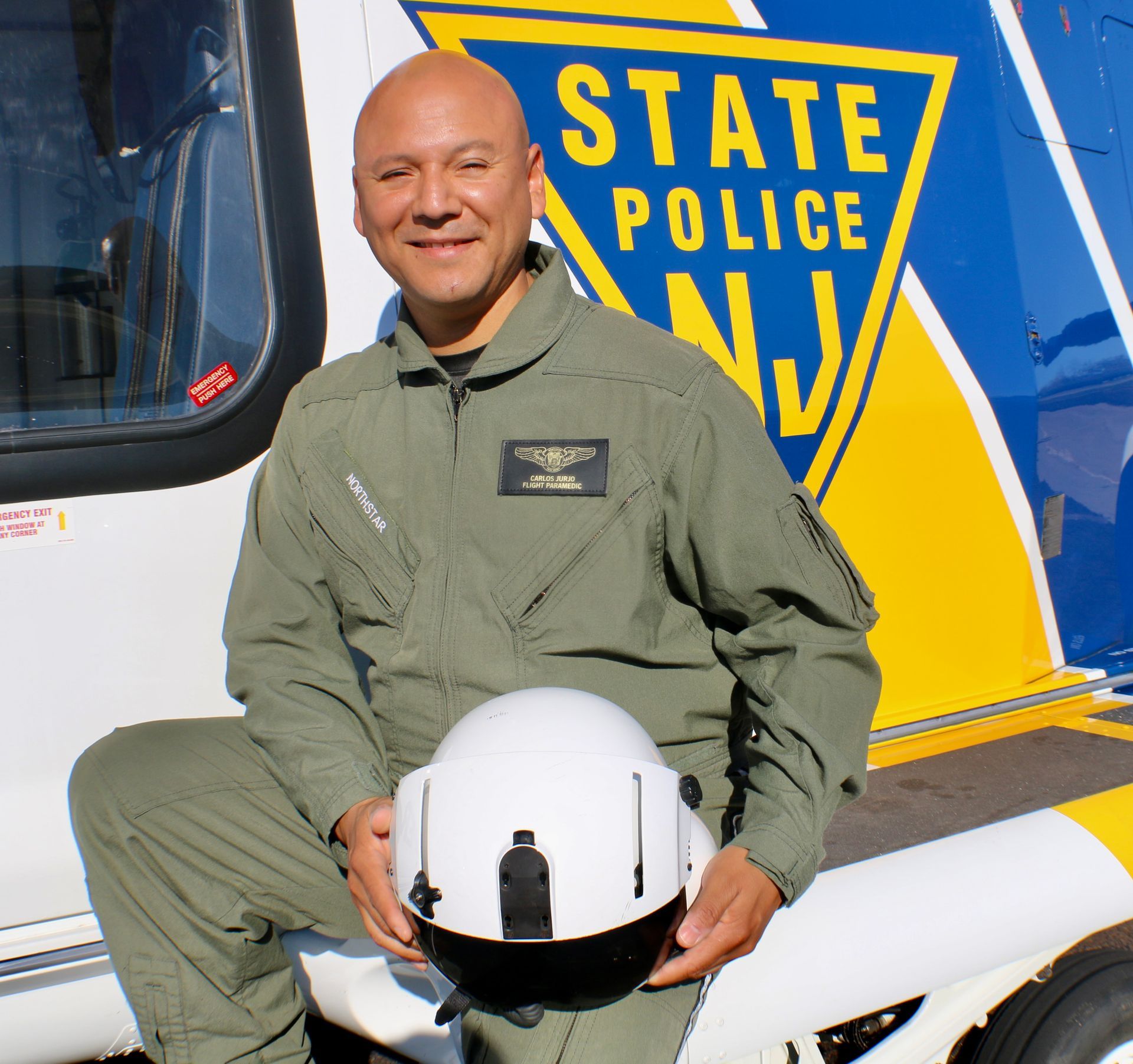 A man in a state police uniform sits on a motorcycle