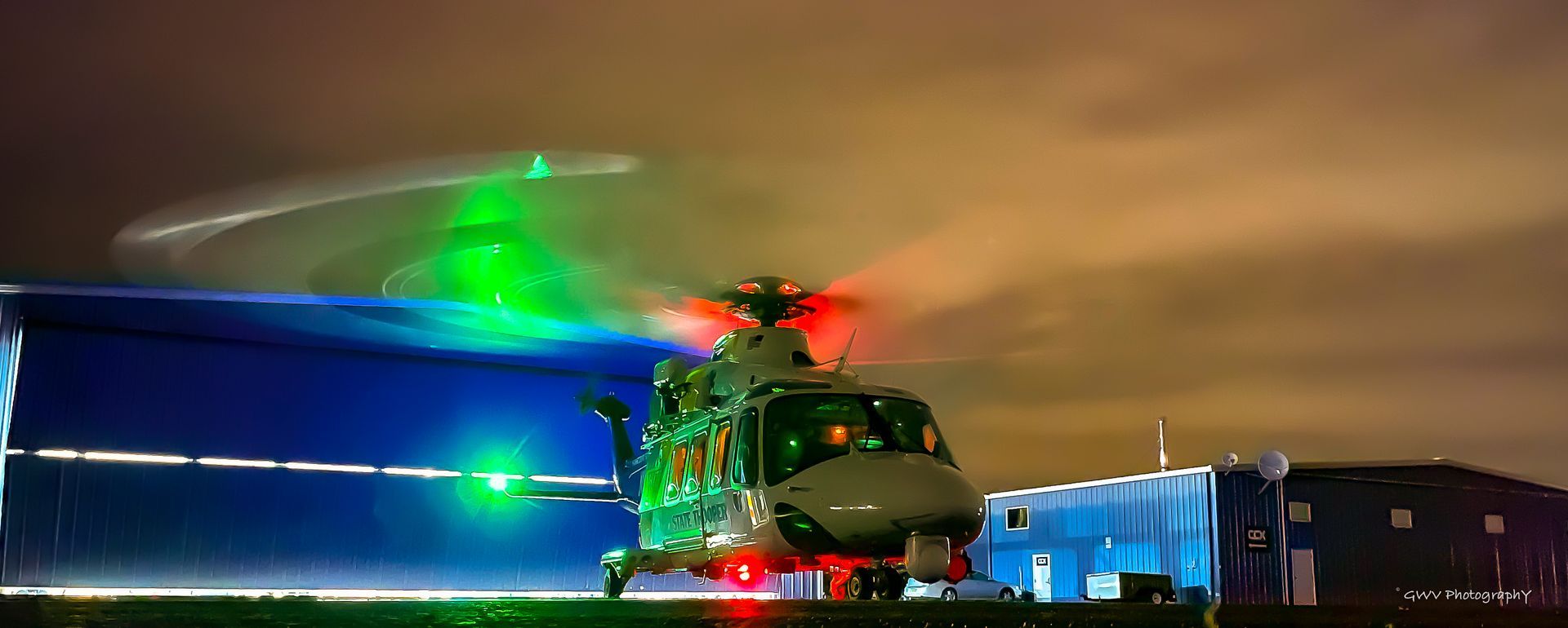 A helicopter is sitting on top of a runway at night.
