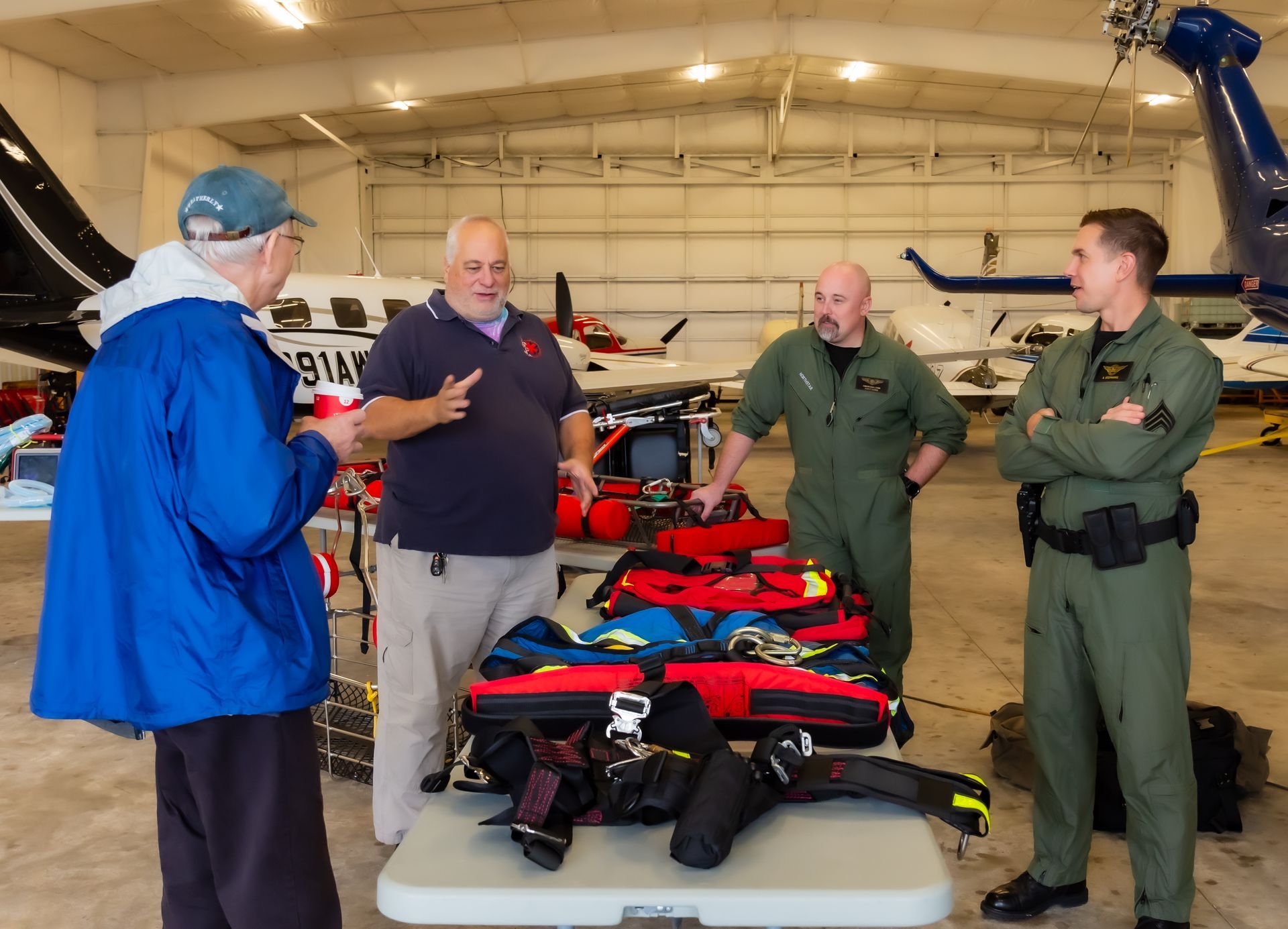 A group of men standing around a table with a helicopter in the background