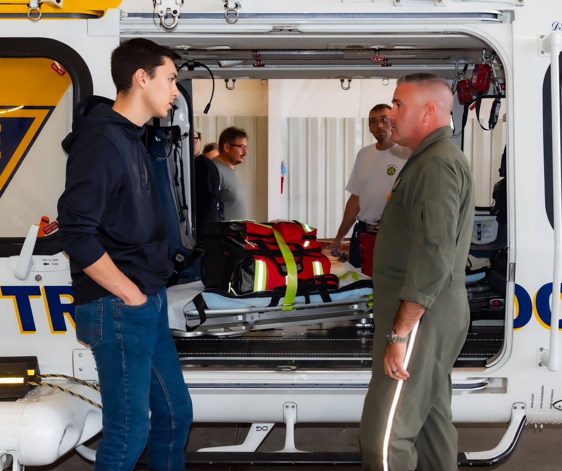 Two men are standing in front of an ambulance that says tf on it