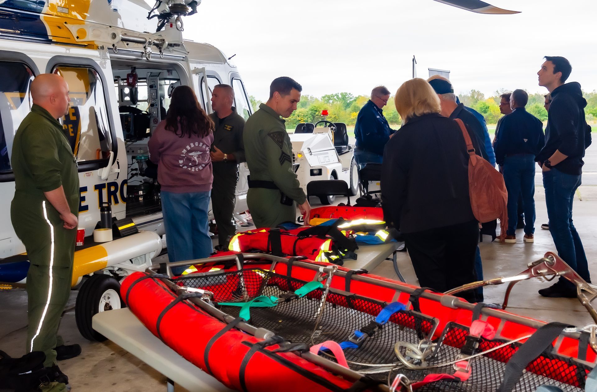 A group of people standing in front of a helicopter that says metro