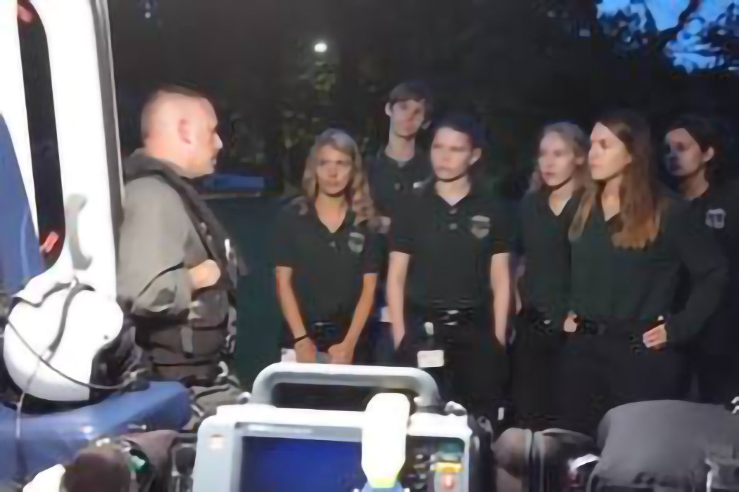 A group of people are standing in front of an ambulance.
