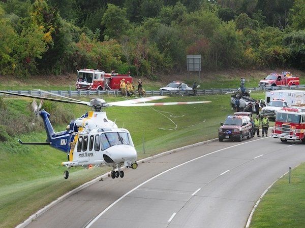 A helicopter is landing on the side of a road