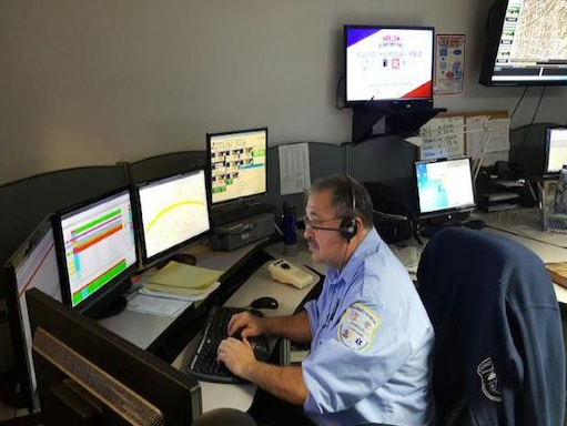 A man wearing a headset is sitting at a desk using a computer