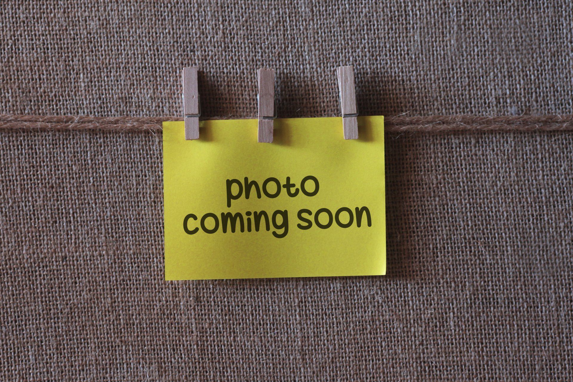 A yellow sign that says photo coming soon on it