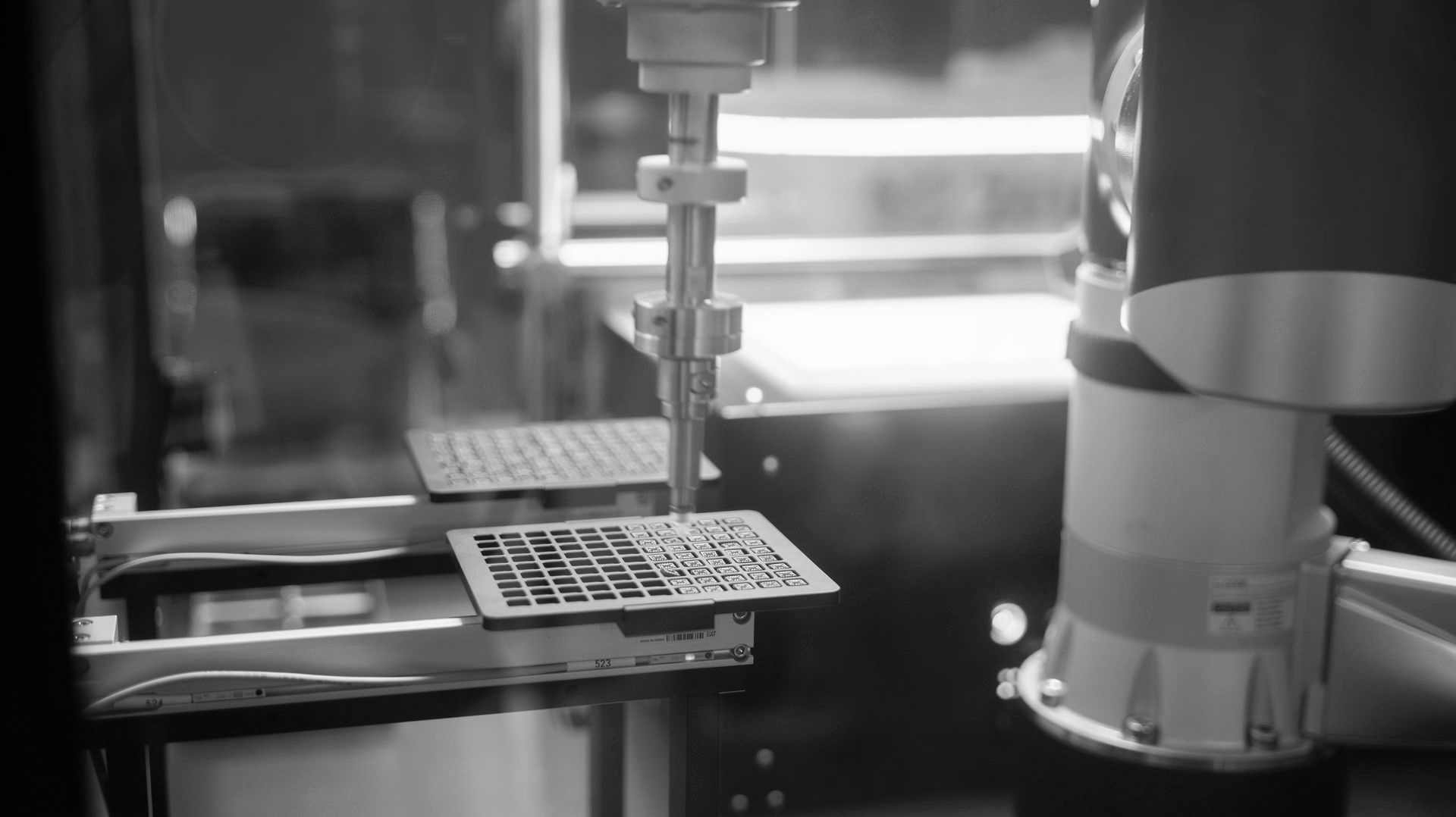 Robotic arm working beside a conveyor in an industrial factory setting.