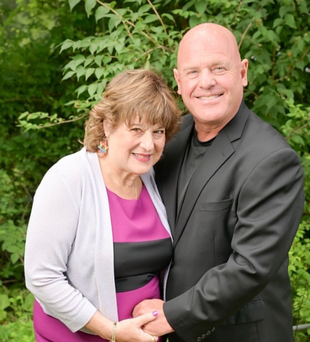 A man and a woman are sitting on a couch talking to a woman.