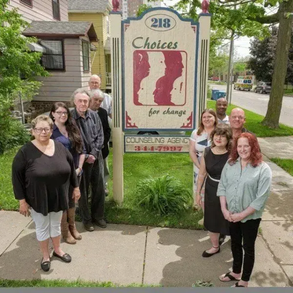 A group of people standing in front of a choices for change sign