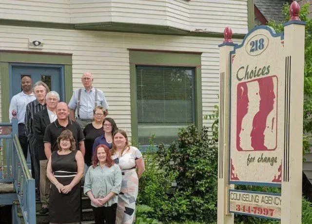 A group of people standing in front of a choices for change sign.