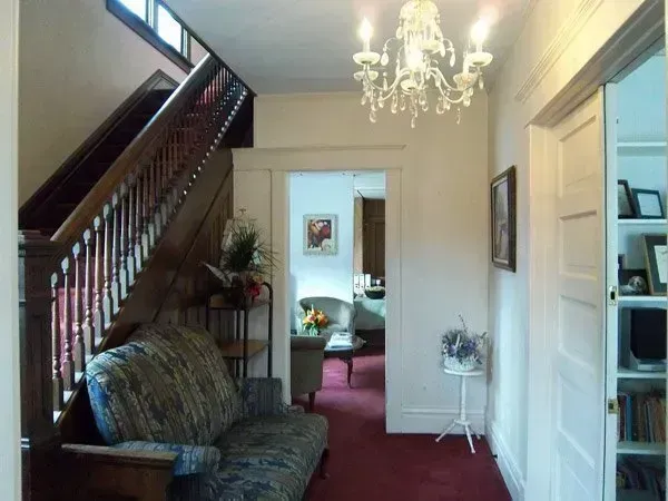 A hallway with a couch and a chandelier hanging from the ceiling