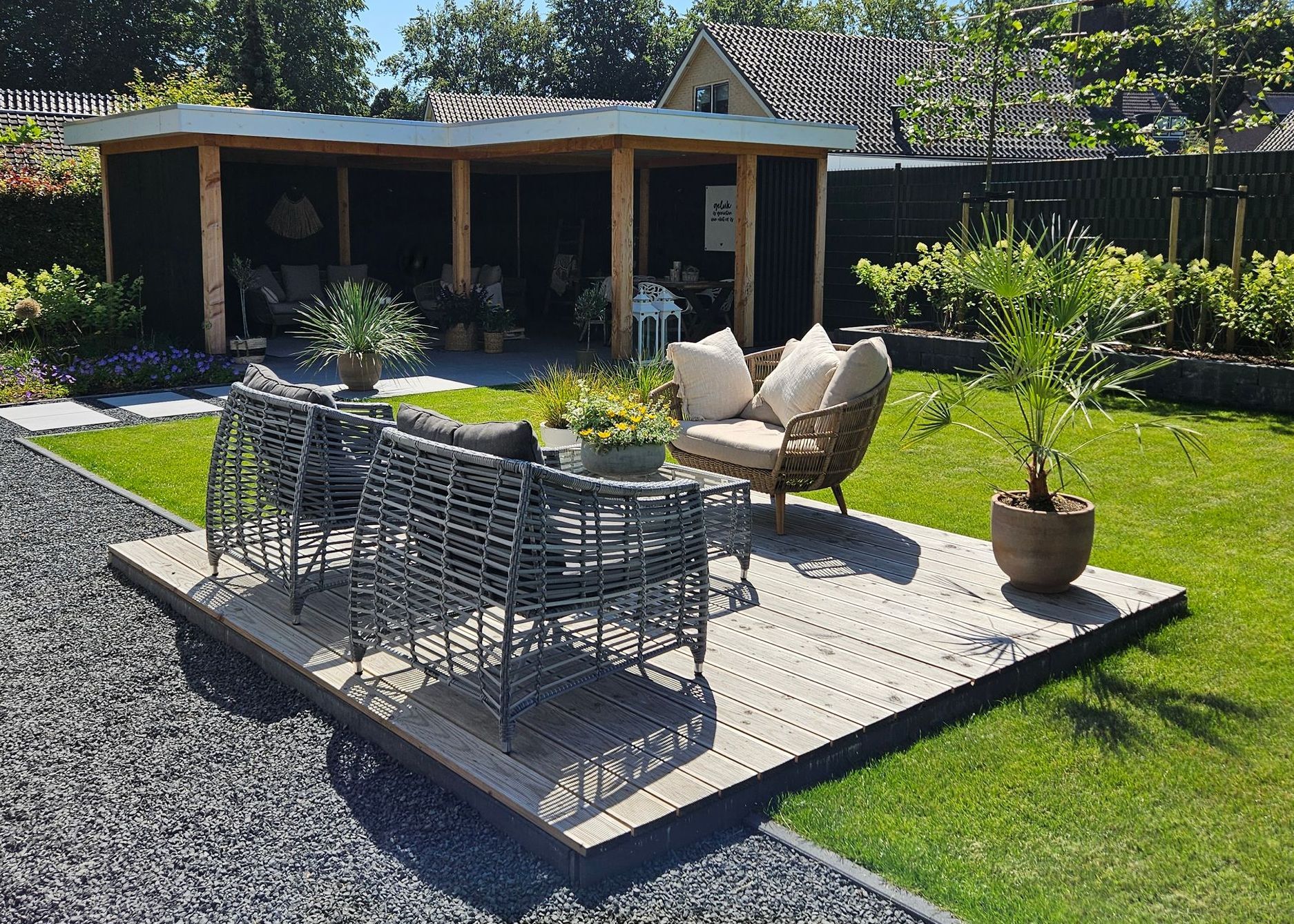 Een tuin met een stenen pad en houten pergola.