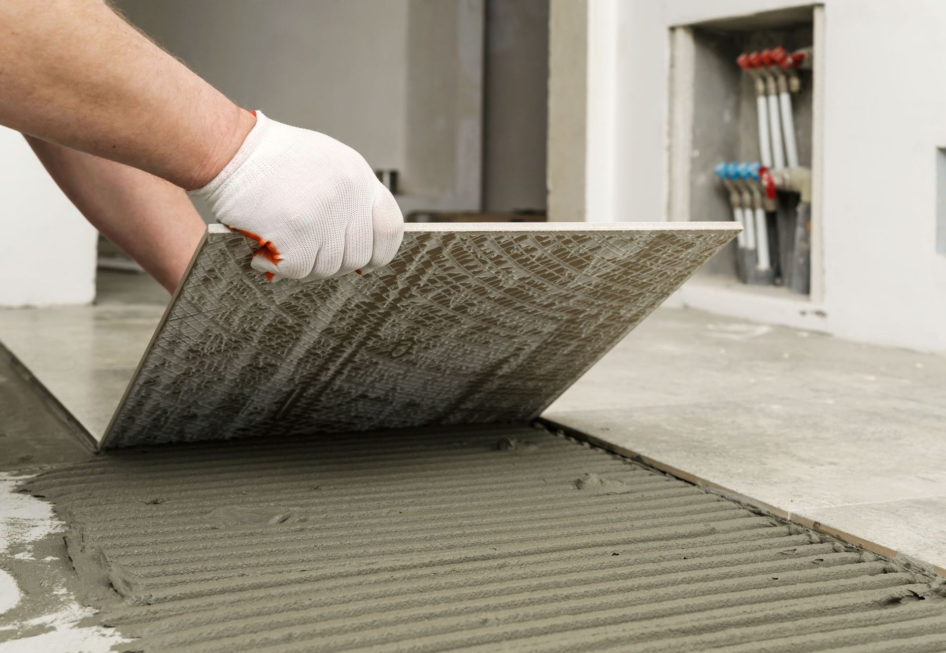 laying ceramic tiles worker placing floor