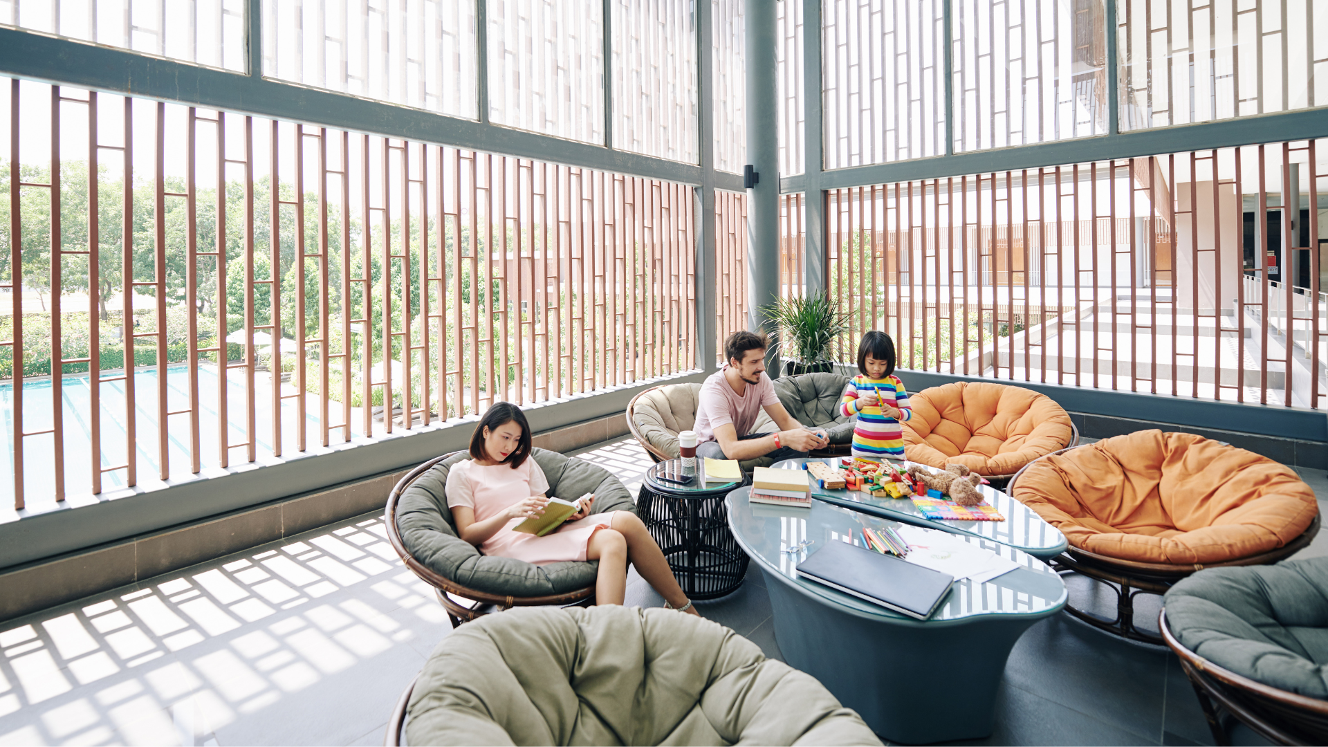A family is sitting in chairs in a living room.