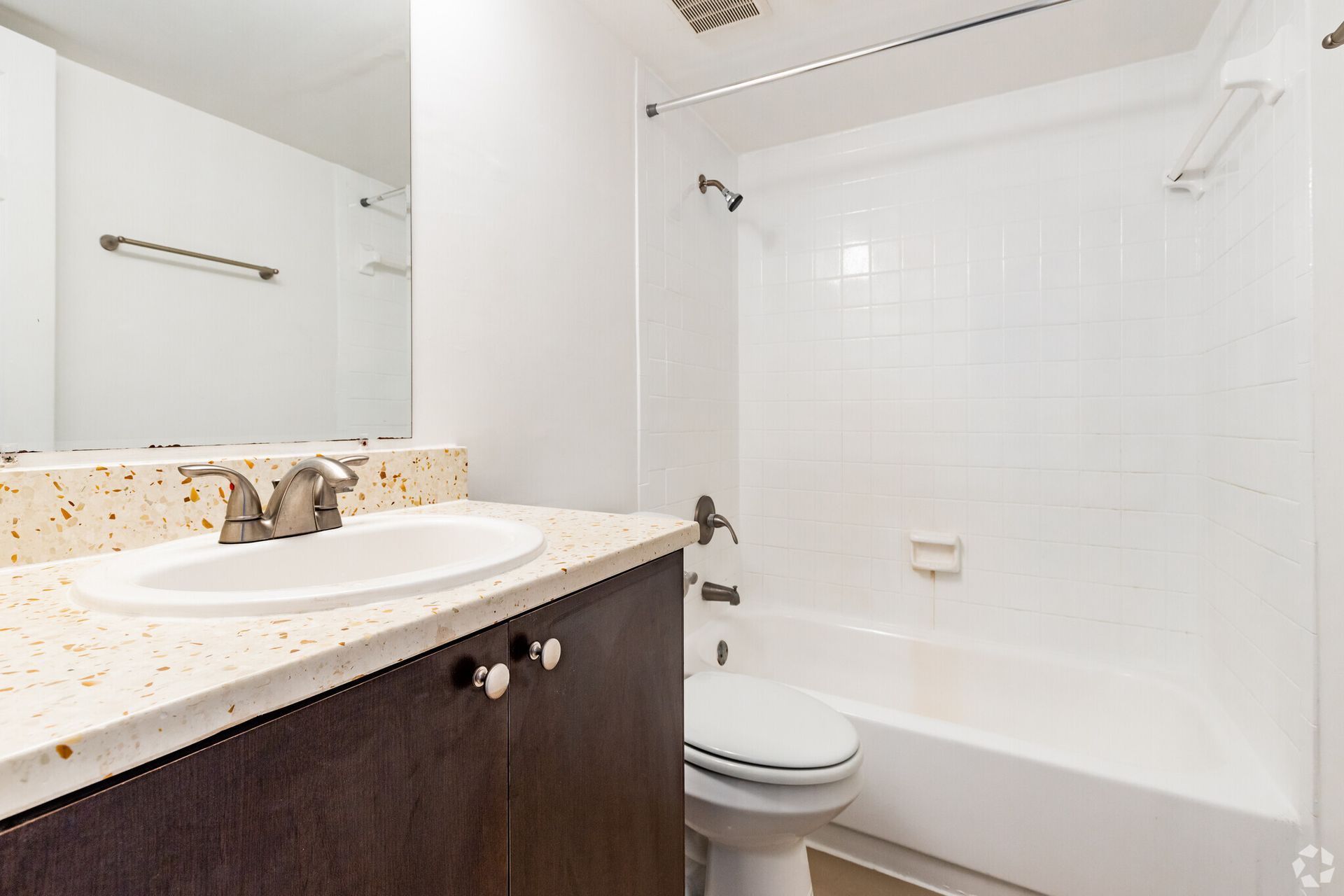 A bathroom with a sink , toilet , bathtub and mirror.