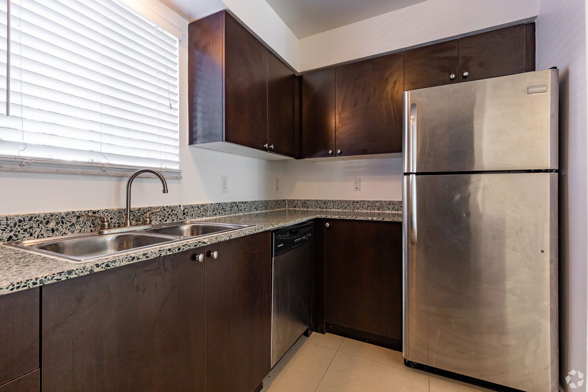 A kitchen with stainless steel appliances and a stainless steel refrigerator.