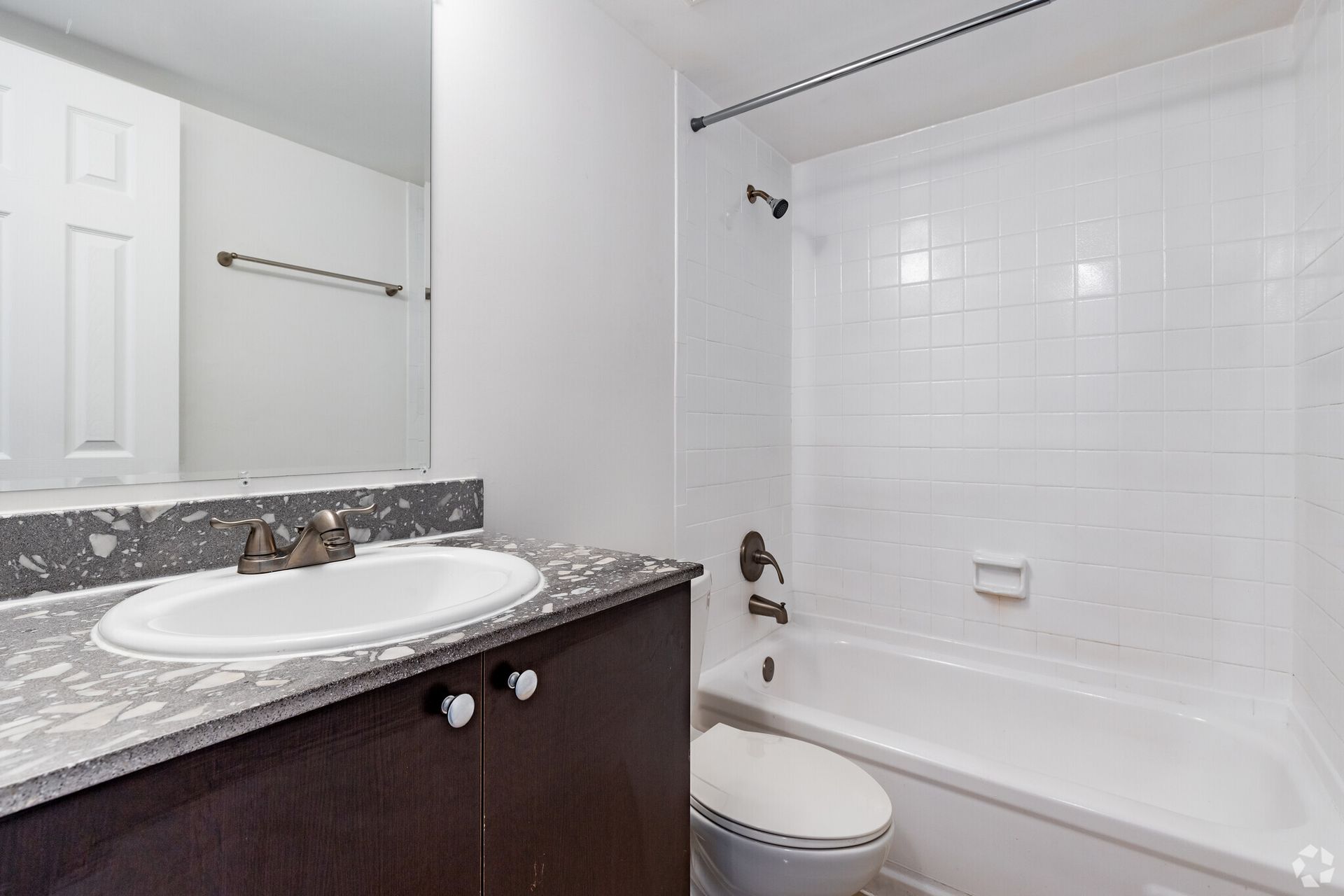 A bathroom with a sink , toilet , bathtub and mirror.