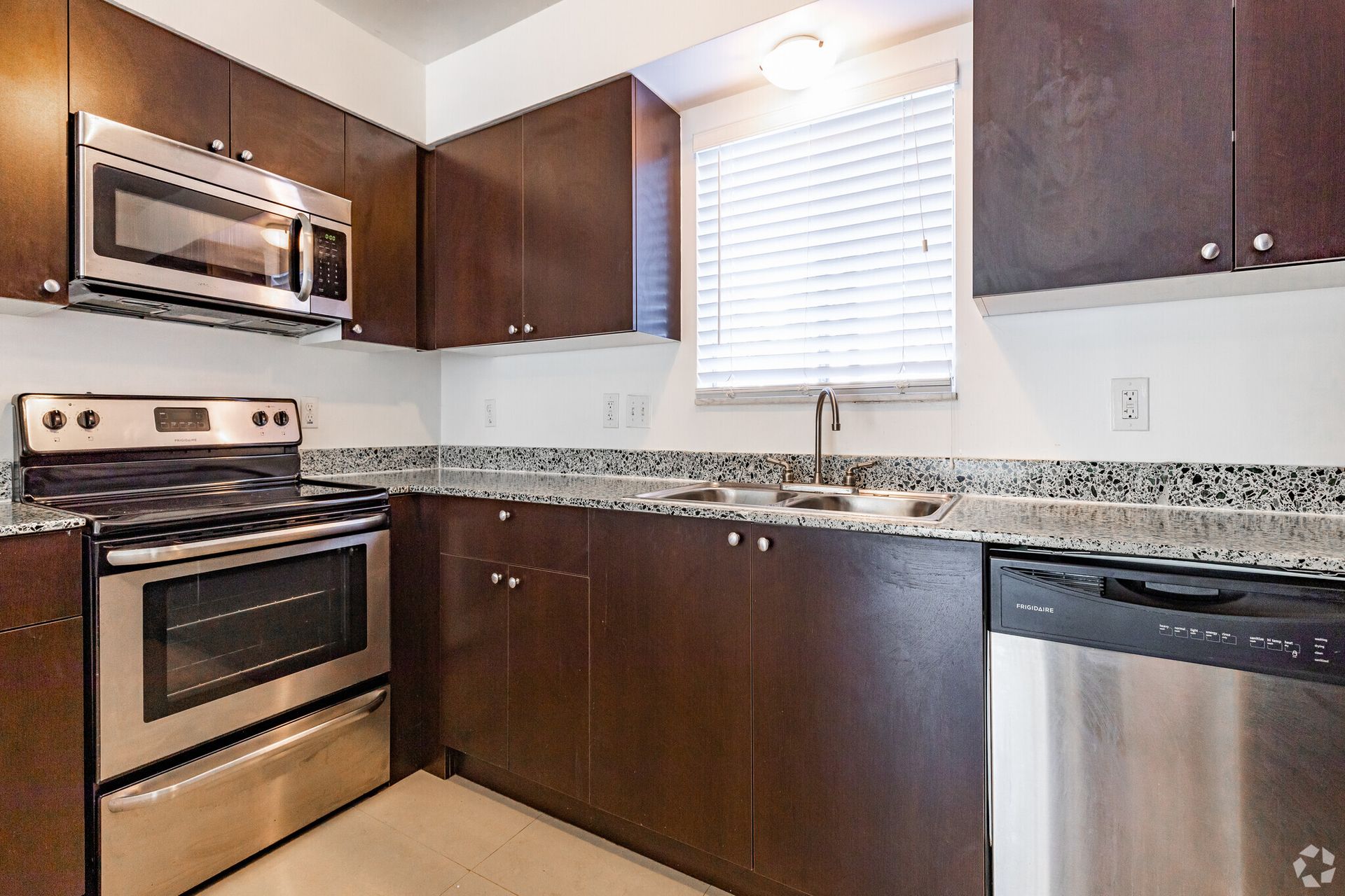 A kitchen with stainless steel appliances and wooden cabinets