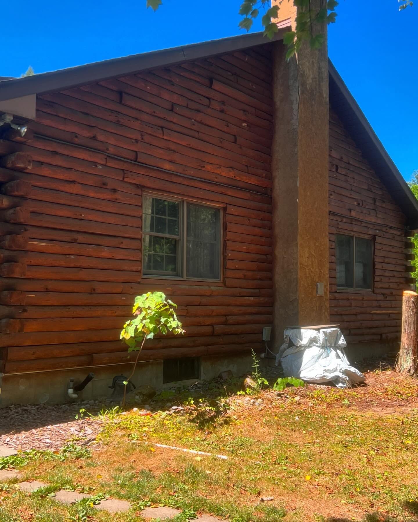 A log cabin with a chimney on the side of it