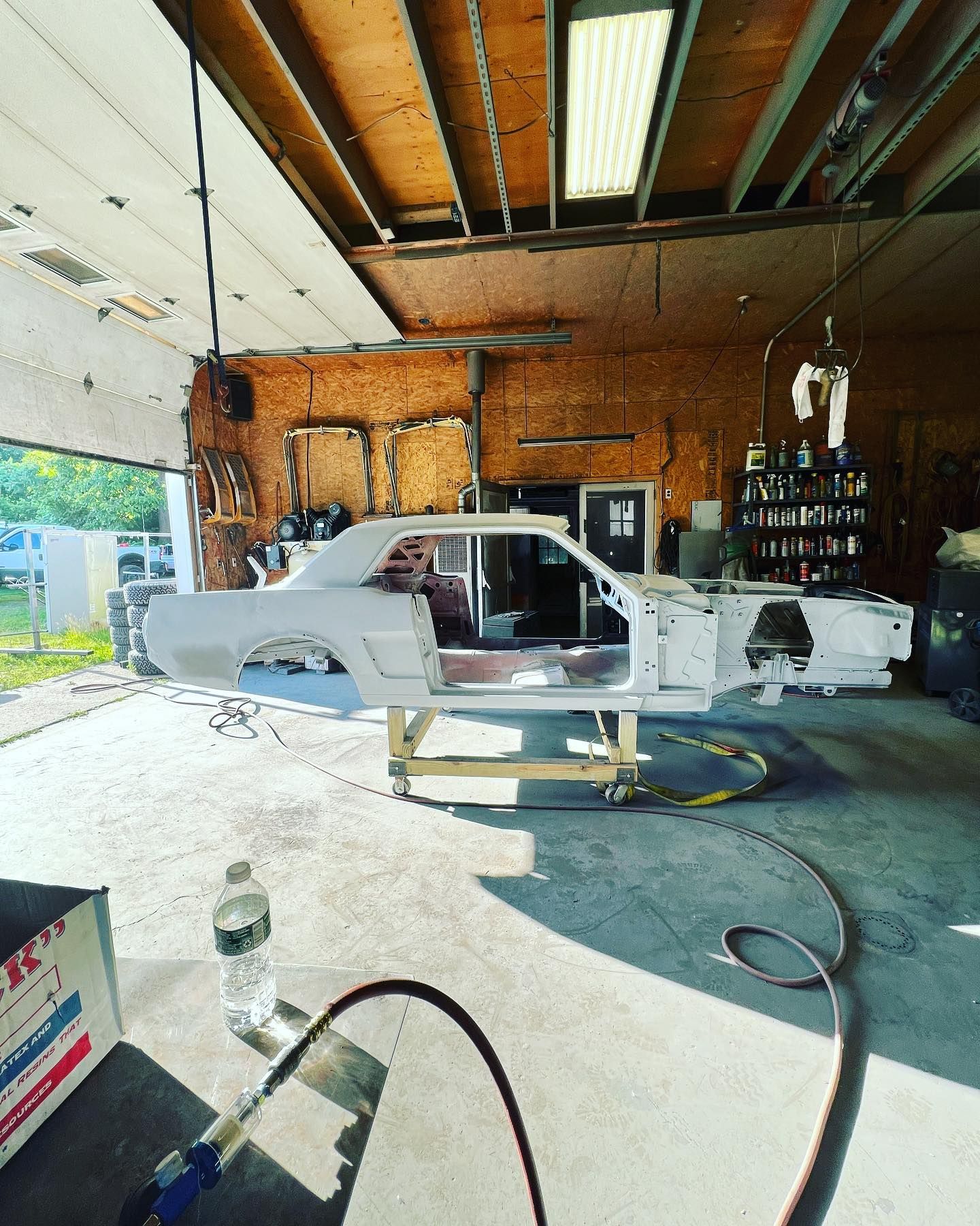 A white car is being built in a garage
