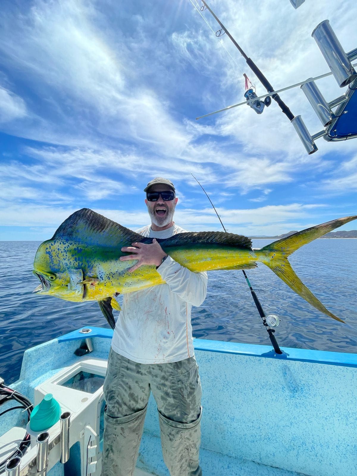 Un hombre sostiene un pez grande en un barco.