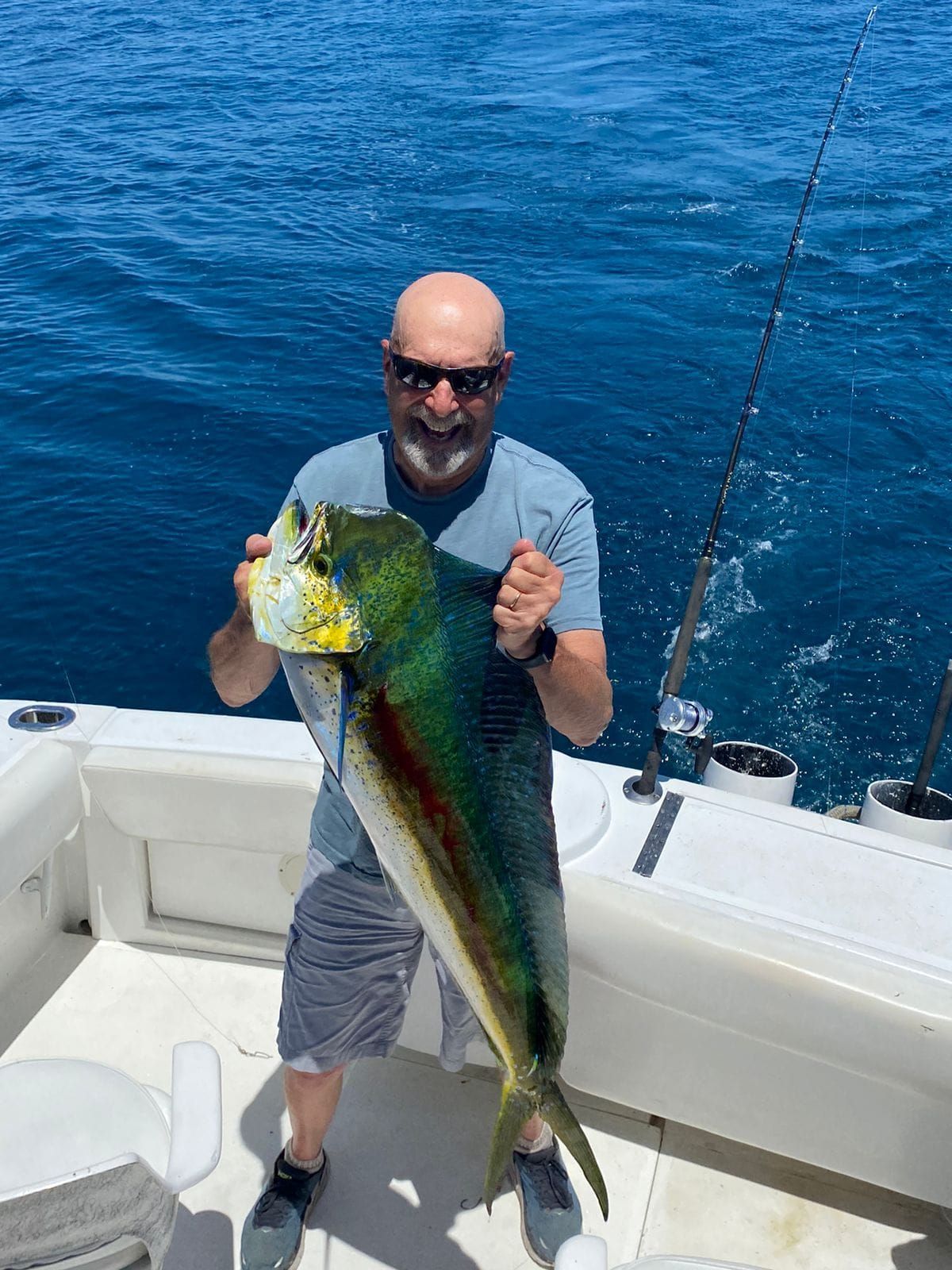 Un hombre sostiene un pez grande en un barco.