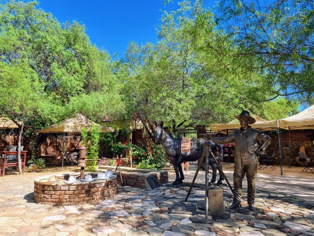 Uma estátua de um homem parado ao lado de uma estátua de uma zebra.