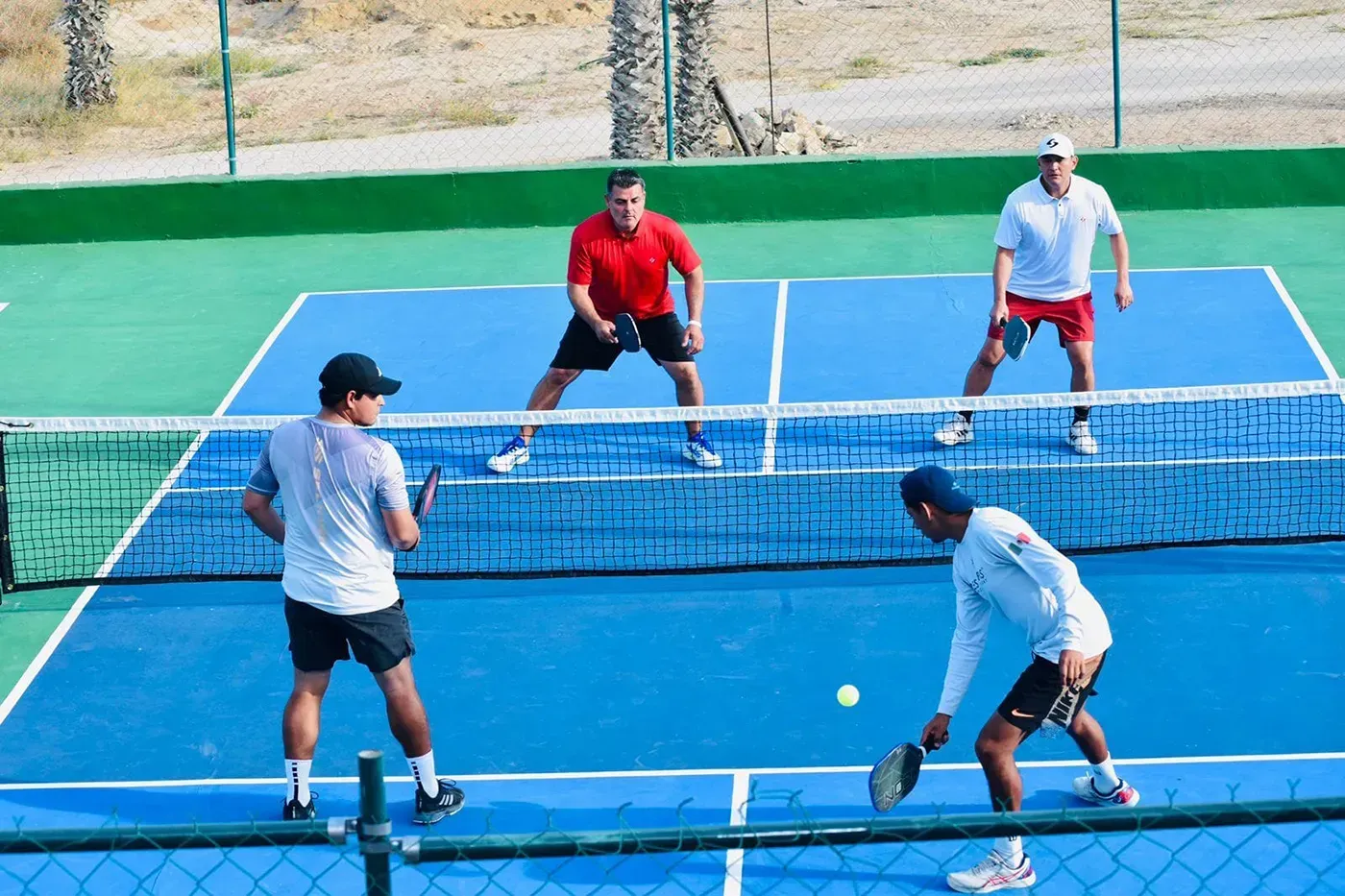 Um grupo de homens está jogando tênis em uma quadra.