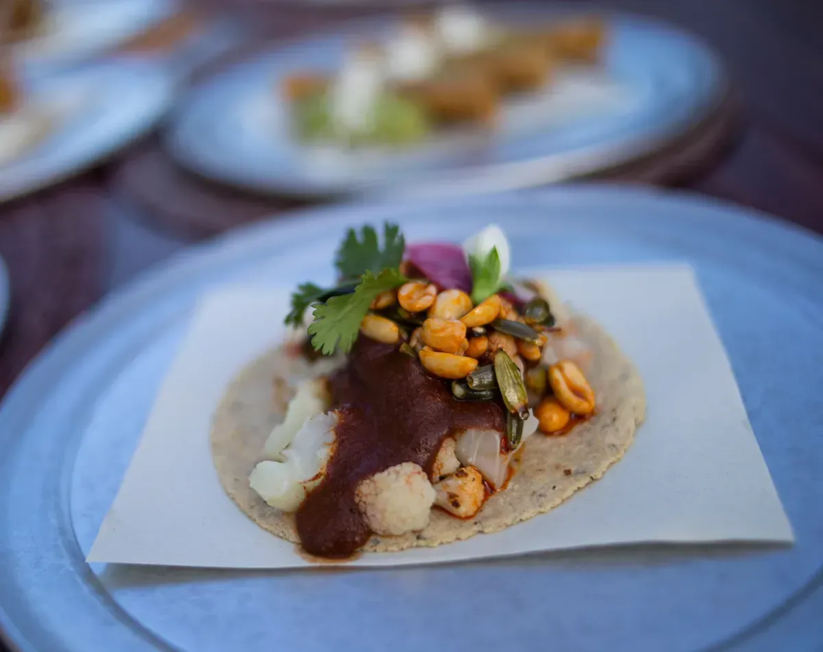 Um close de um taco em um prato sobre uma mesa.